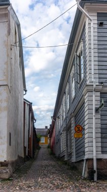 Finlandiya 'nın Porvoo şehrinde yaz akşamları kaldırımlı sokaklar ve renkli boyanmış eski ahşap evler  