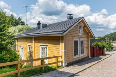 Finlandiya 'nın Porvoo şehrinde yaz akşamları kaldırımlı sokaklar ve renkli boyanmış eski ahşap evler  