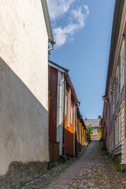 Finlandiya 'nın Porvoo şehrinde yaz akşamları kaldırımlı sokaklar ve renkli boyanmış eski ahşap evler  