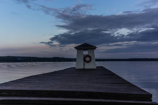 A traditional lifeguard and changing dress shelter on a wooden pier near the town of Porvoo in Finland at sunset in summer