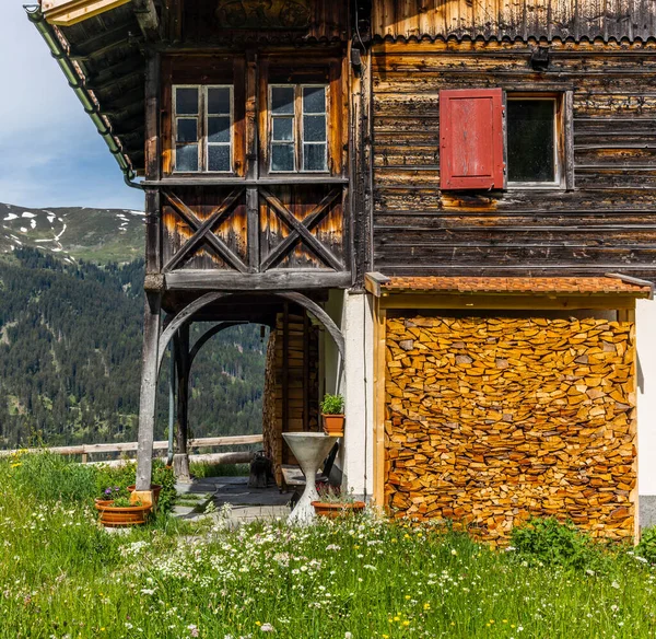 春の間 スイスの緑の草やカラフルな花に覆われた高山草原の古い伝統的な木製のシャレー — ストック写真