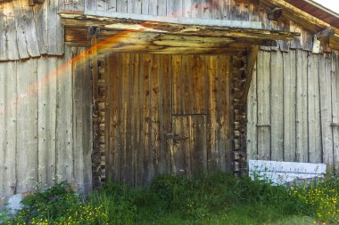 Yaz boyunca İsviçre 'deki dağlık çayırlarda eski bir ahır girişi.
