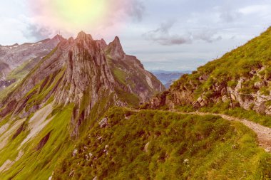 Güneş, İsviçre 'nin Appenzell kentindeki Aescher uçurumunun etrafındaki Alpstein dağ sırasının Görkemli Schaefler zirvesinde parlıyor.