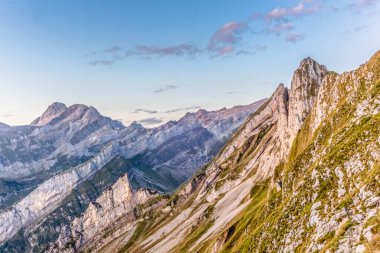 İsviçre 'nin Appenzell dağlarındaki görkemli Schaefler zirvesinin dik yamacında, Seealpsee vadisini kaplayan sisle birlikte renkli bir gün doğumu.