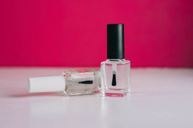 Pembe arka planda tırnak cilası olan şişe. Reklam afişleri, broşürler, dergiler için ideal. manikür ve pedikür stüdyosu konsepti