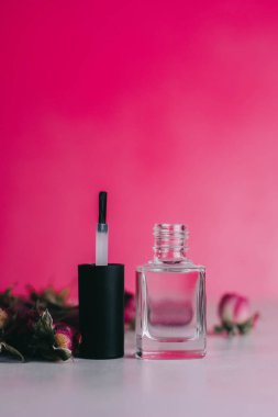Pembe arka planda tırnak cilası olan şişe. Reklam afişleri, broşürler, dergiler için ideal. manikür ve pedikür stüdyosu konsepti