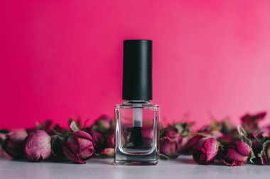 Pembe arka planda tırnak cilası olan şişe. Reklam afişleri, broşürler, dergiler için ideal. manikür ve pedikür stüdyosu konsepti