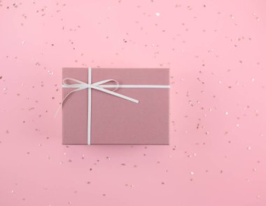 Pembe bir arka planda pembe bir hediye kutusu..