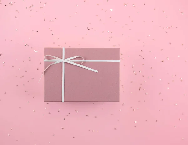 Pembe bir arka planda pembe bir hediye kutusu..