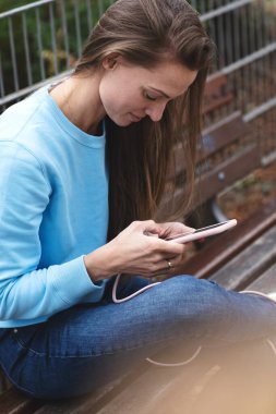 Genç bayan telefonda bir mesaj okuyor..