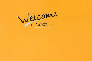 Davetiye. Kopya alanı olan davet logosu. Mağazalar, oteller, etkinlikler, tatiller için pankart. Turuncu ahşap arka planda kalibreli el yazısıyla yazılmış.
