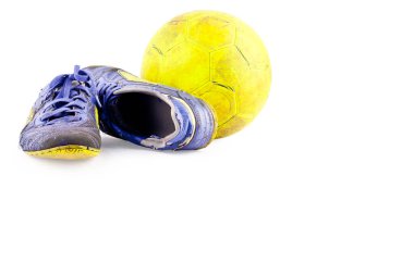 Eski futbol ayakkabıları hasarlı ve kirli sarı futsal topu beyaz arka plan futbol nesnesinde izole edilmiş.