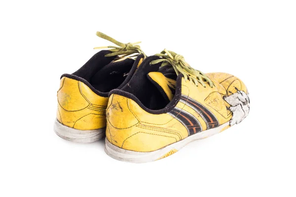 Beyaz arka planda eski hasarlı sentetik futbol ayakkabıları izole edilmiş.