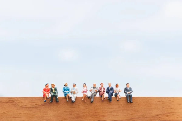 Miniaturní Osob Skupina Podnikatelů Sedí Dřevěné Podlaze Pozadí Modré Oblohy — Stock fotografie