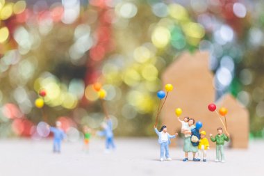 Minyatür insanlar: mutlu aile holding balon Park renkli bokeh arka plan, mutlu aile ilişkileri ve kaygısız boş zaman kavramı ile