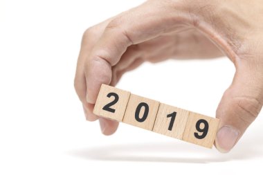 Ahşap blok 2019 beyaz arka plan, mutlu yeni yıl kavramı üzerinde tutan el