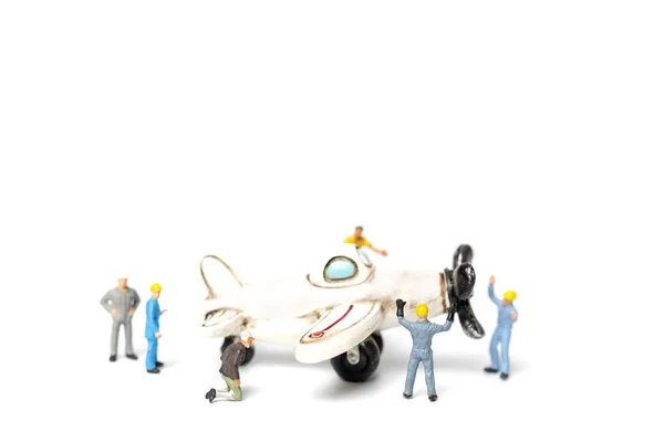 微型人 工人队修理玩具飞机在白色背景 — 图库照片