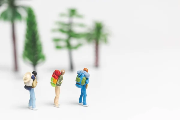 Pessoas em miniatura: Viajante com mochila andando sobre fundo branco — Fotografia de Stock