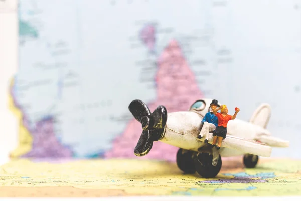 Miniaturmenschen Flugzeug Mit Weltkarte Hintergrund Reisekonzept — Stockfoto