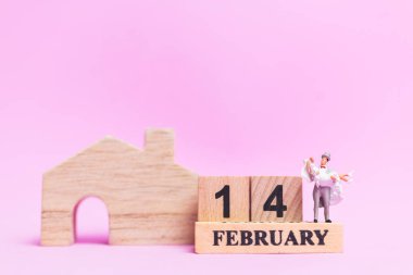 Minyatür insanlar düğün, Gelin ve damat çift pembe arka plan, Sevgililer günü kavramı üzerinde