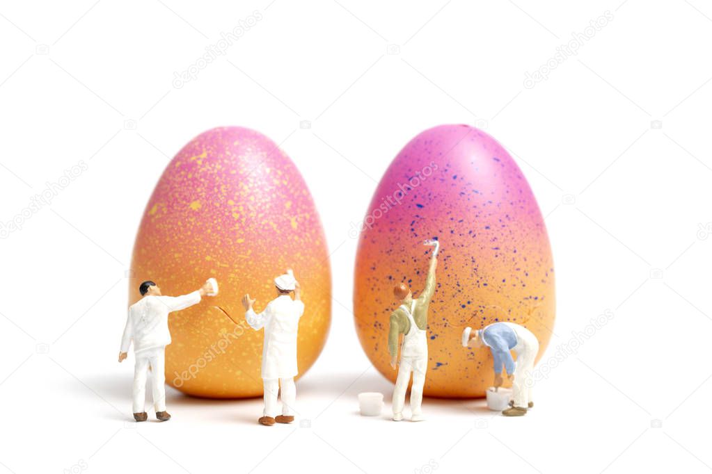 Miniature people  painting Easter-eggs for Easter day on white background