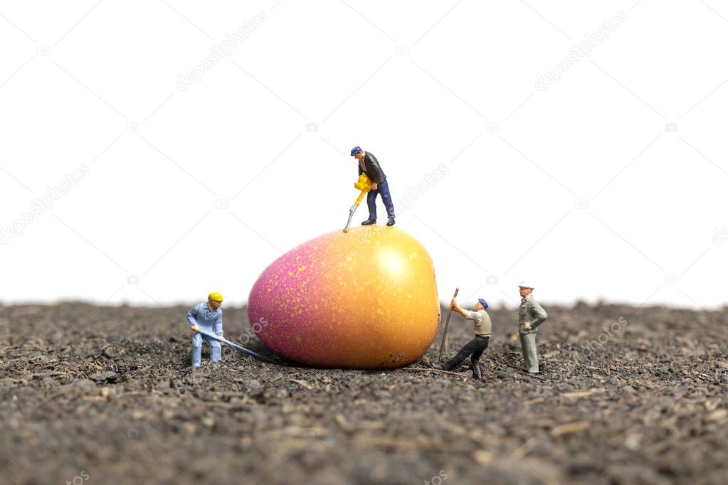 Miniature people work at Easter-eggs for Easter day with white background