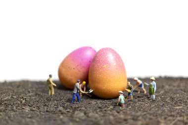 Miniature people work at Easter-eggs for Easter day with white background clipart