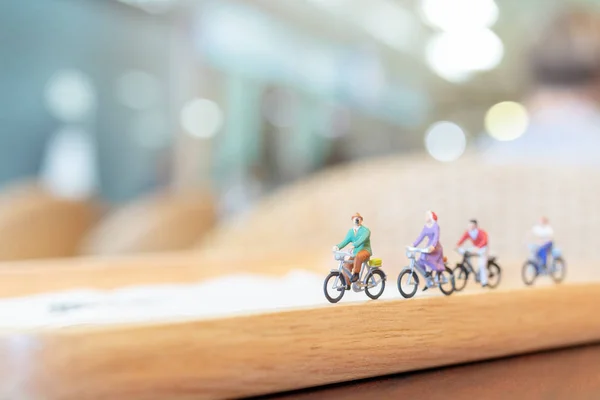 Pessoas em miniatura pedalando na ponte de madeira — Fotografia de Stock