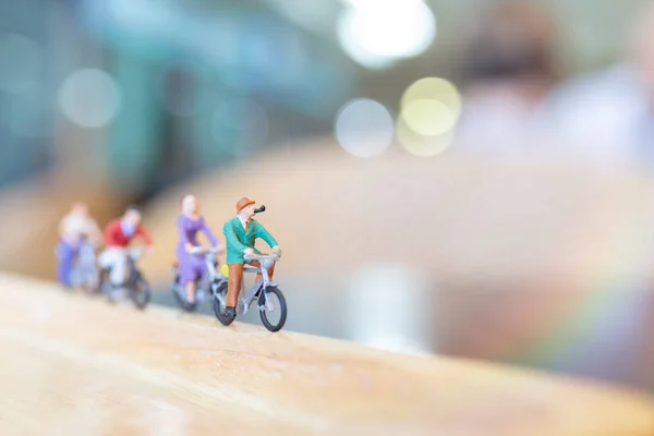 Pessoas em miniatura pedalando na ponte de madeira — Fotografia de Stock