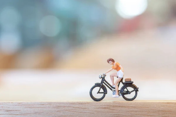 Pessoas em miniatura pedalando na ponte de madeira — Fotografia de Stock