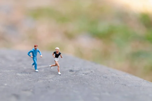Pessoas em miniatura a correr na rocha — Fotografia de Stock