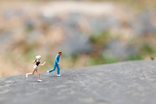 Pessoas em miniatura a correr na rocha — Fotografia de Stock