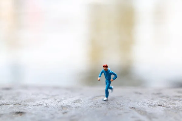 Personas en miniatura corriendo en la roca — Foto de Stock