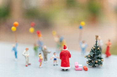 Minyatür insanlar: mutlu bir aile için Noel Baba holding hediye