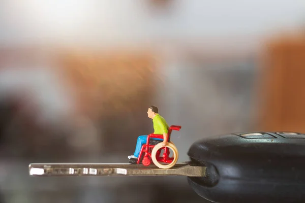 Miniature people : Disabled man sitting in wheelchair — Stock Photo, Image