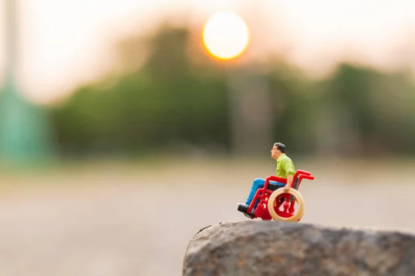 Miniaturmenschen: Behinderter sitzt im Rollstuhl — Stockfoto