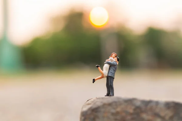 Miniaturowy lud: para stojący na skale urwiska — Zdjęcie stockowe