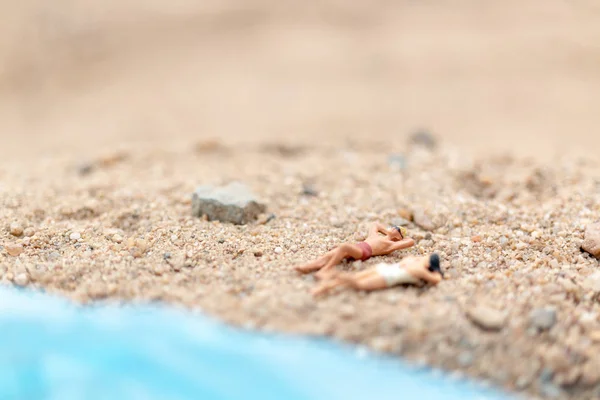 Personas en miniatura con traje de baño relajándose en la playa — Foto de Stock