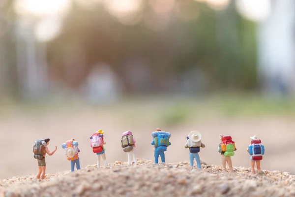Pessoas em miniatura: Viajante com mochila andando na areia — Fotografia de Stock