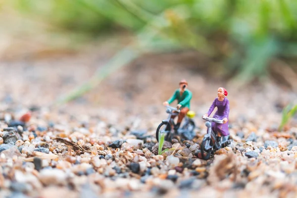 Pessoas em miniatura: Viajantes andando de bicicleta na areia — Fotografia de Stock