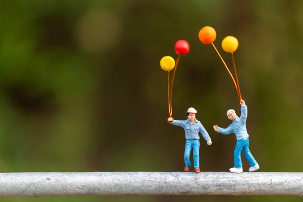 Persone in miniatura: famiglia felice con palloncini colorati — Foto Stock