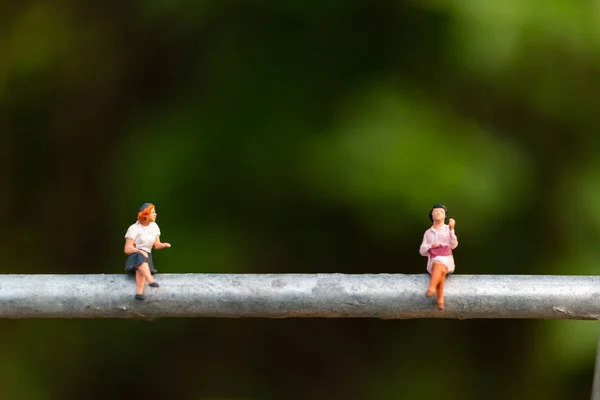 Personas en miniatura: gente de negocios sentada en un cable — Foto de Stock