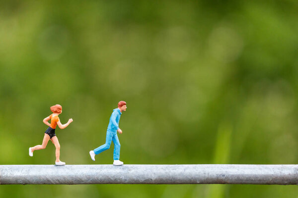 Miniature people : Young people running on a wire 