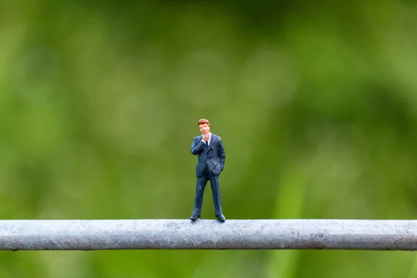 Personas en miniatura: Empresario parado en un alambre — Foto de Stock