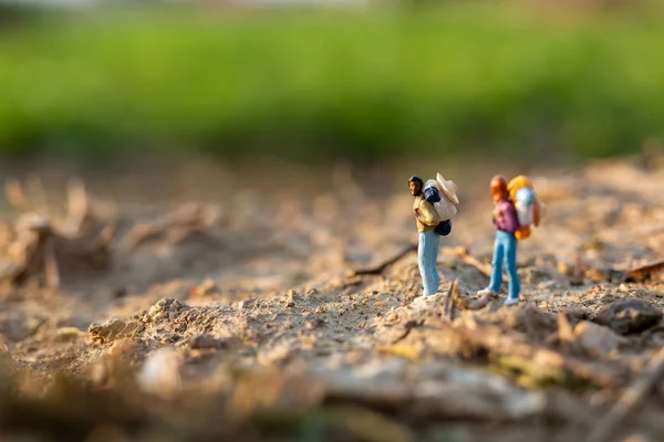 Viajero en miniatura con soporte de mochila y caminar en el prado — Foto de Stock