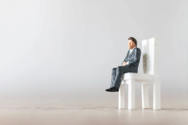 Personas en miniatura: Empresario sentado en una silla — Foto de Stock