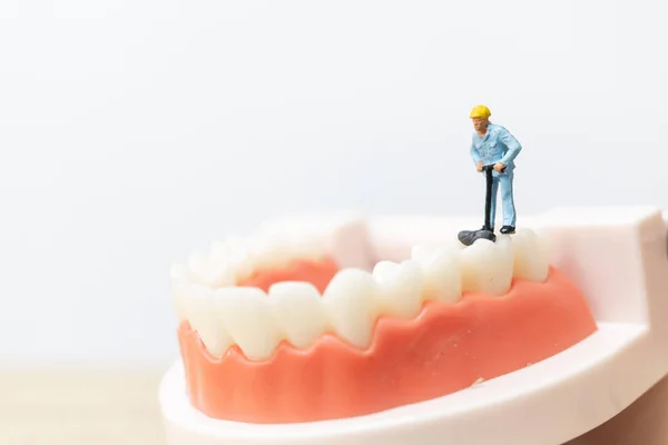 Miniaturmenschen: Arbeiterteam repariert einen Zahn — Stockfoto