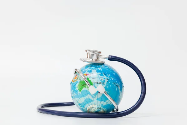 Stethoscope wrapped around globe on white background. — Stock Photo, Image