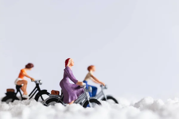 Personas en miniatura: Viajeros en bicicleta sobre fondo de nieve — Foto de Stock