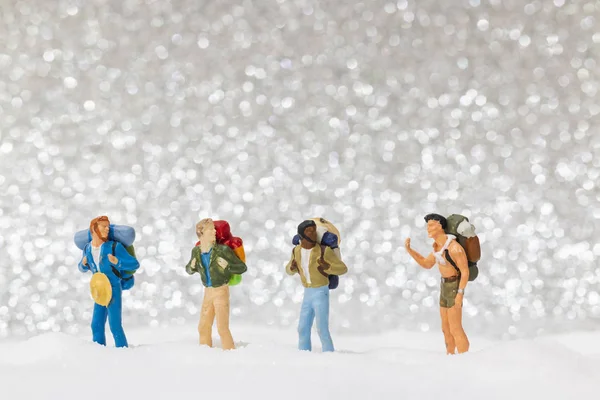 Personas en miniatura: mochilero caminando sobre fondo de nieve — Foto de Stock
